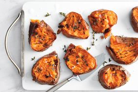 smashed sweet potato pieces with salt and thyme on white tray