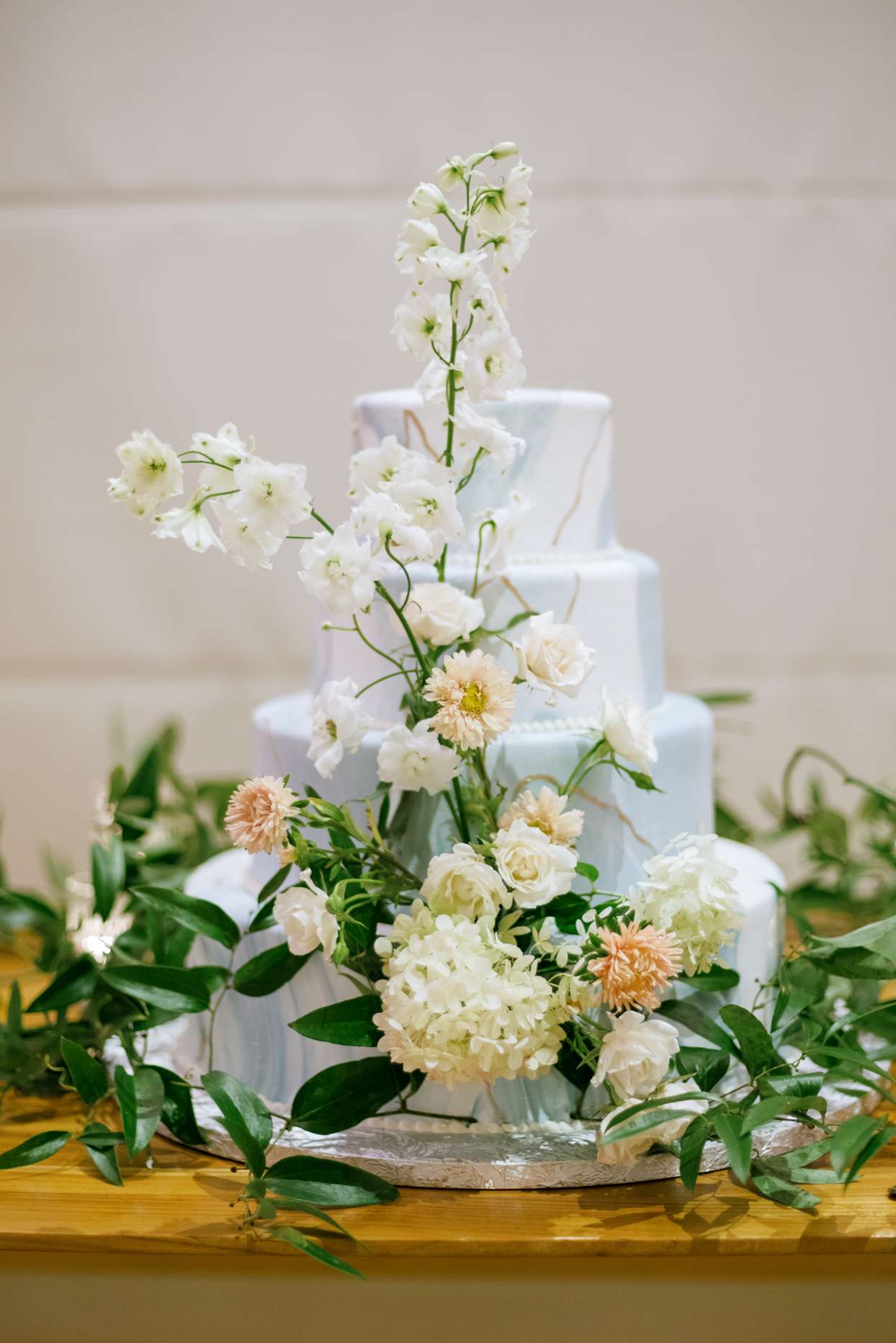 elegant blue and white wedding cake with floral decorations