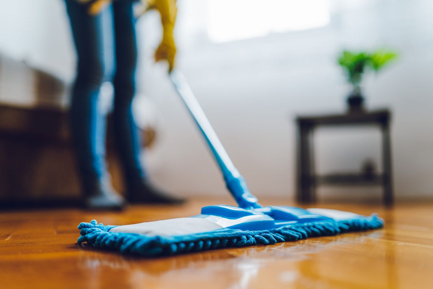 woman mopping with blue mop