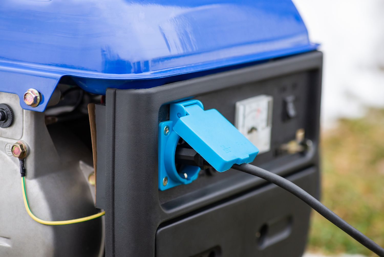 A portable generator with a blue power outlet connected