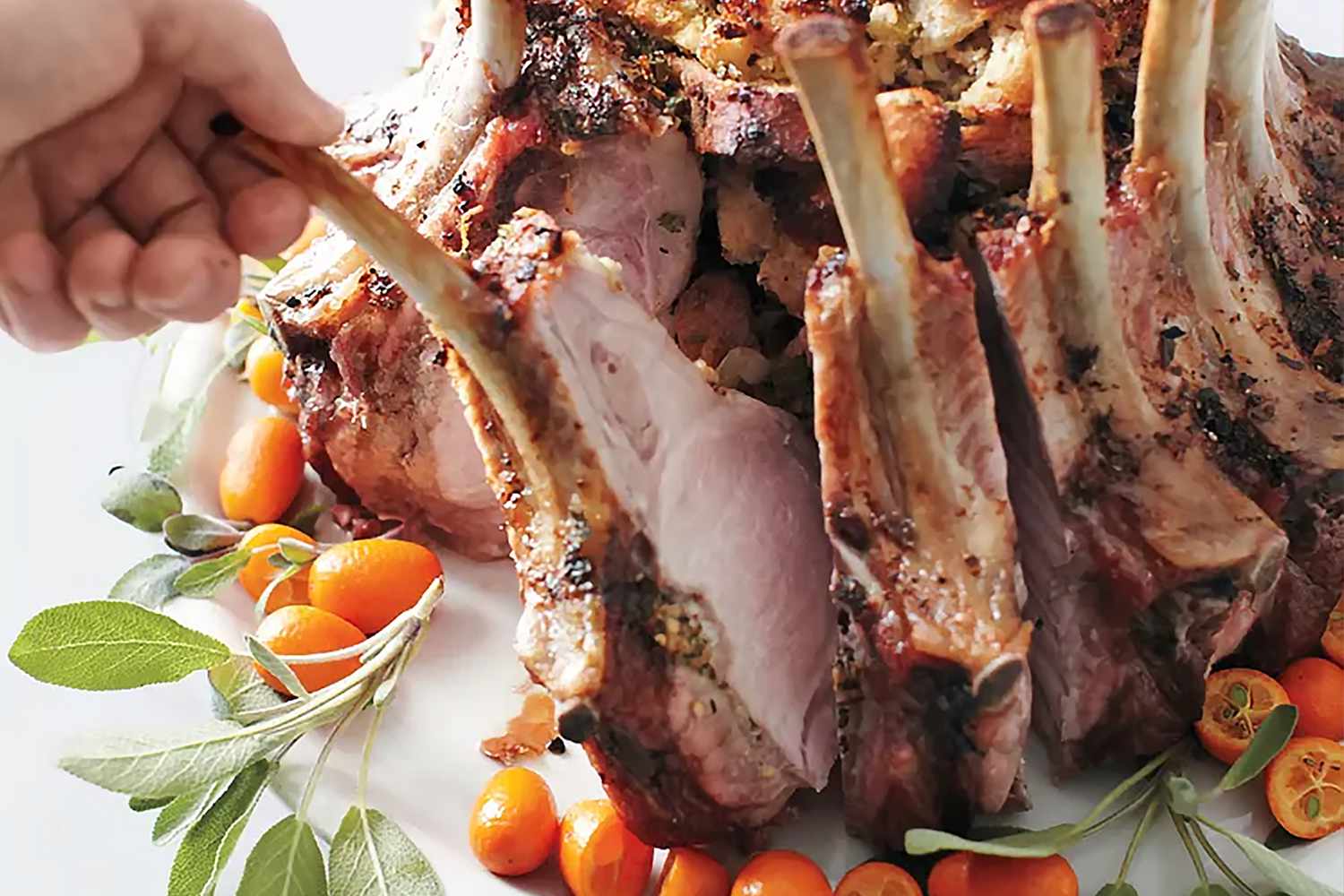 someone pulling out a portion of crown pork roast 