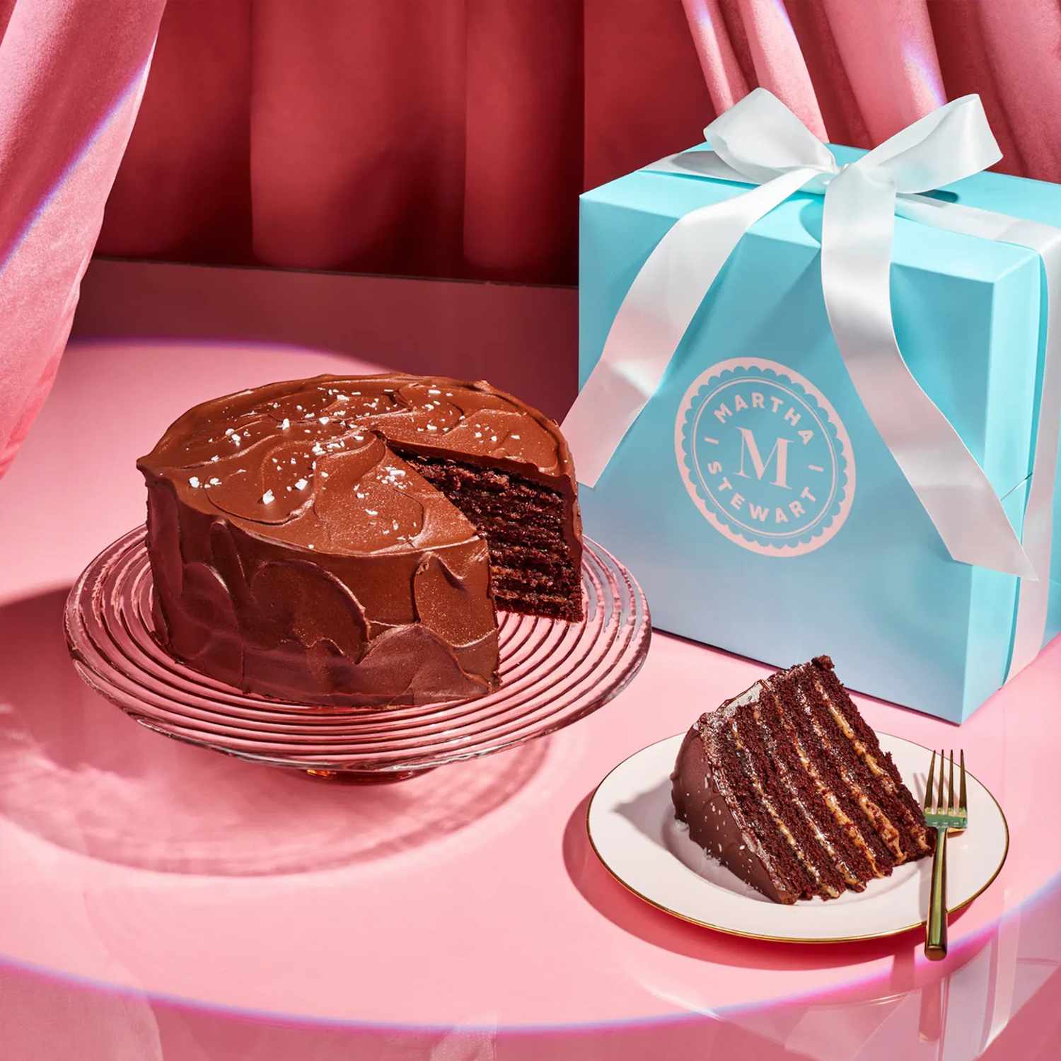 chocolate cake with decorvow blue gift box on pink background