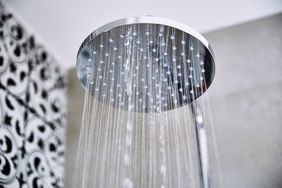 Overhead showerhead spraying water in a bathroom