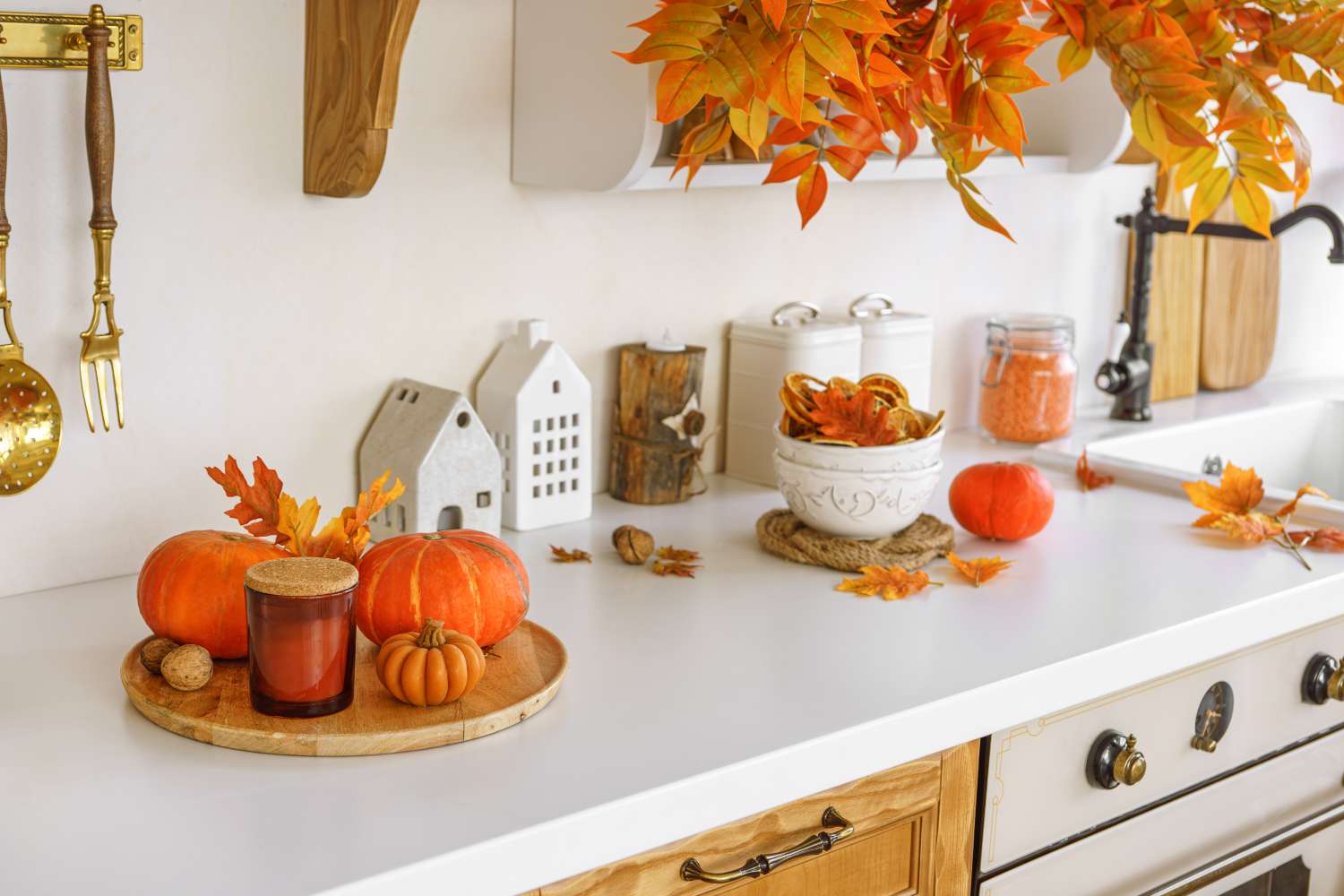 Kitchen counter adorned with small pumpkins autumn leaves and decorative items