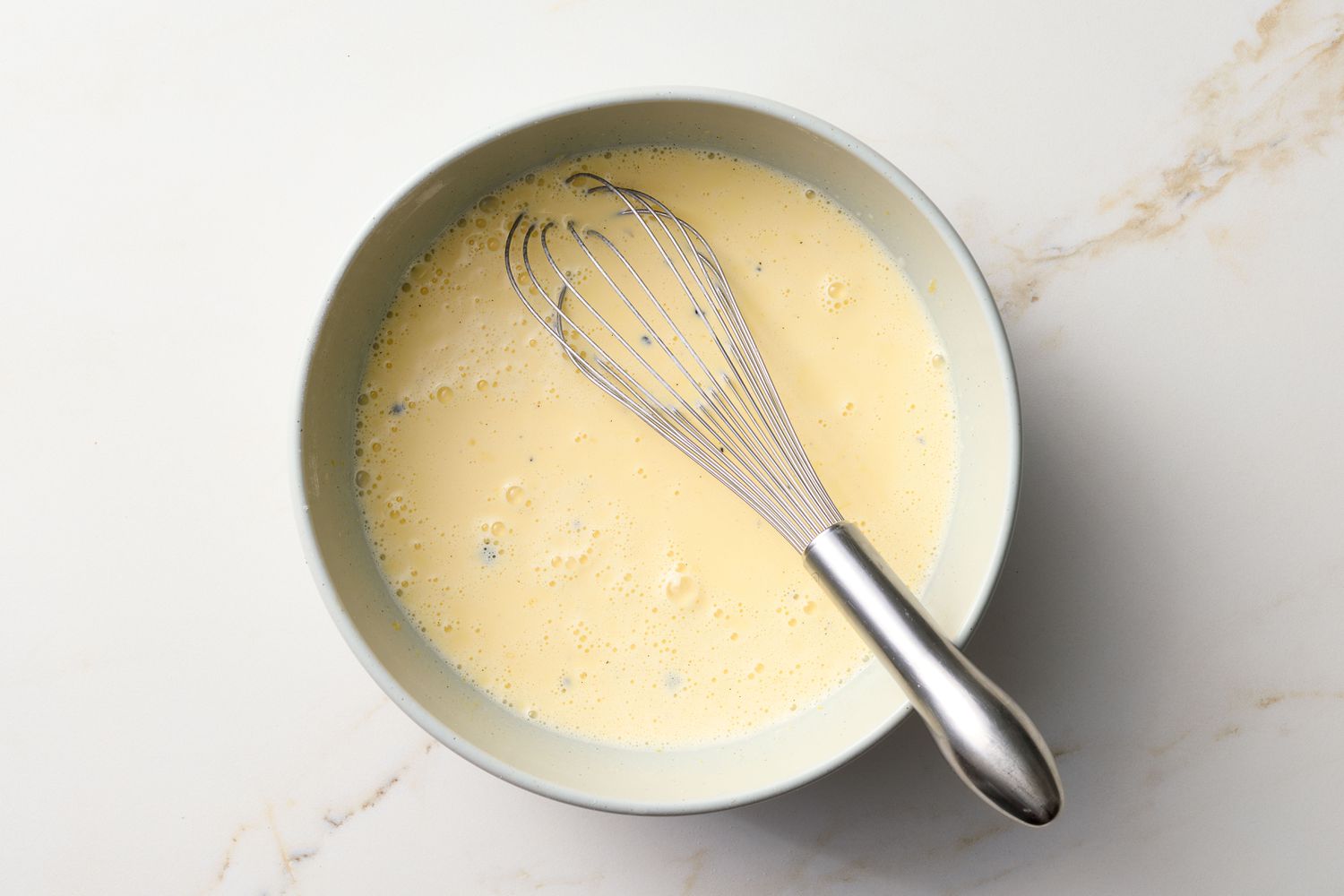 Bowl with whisk and a liquid batter mix