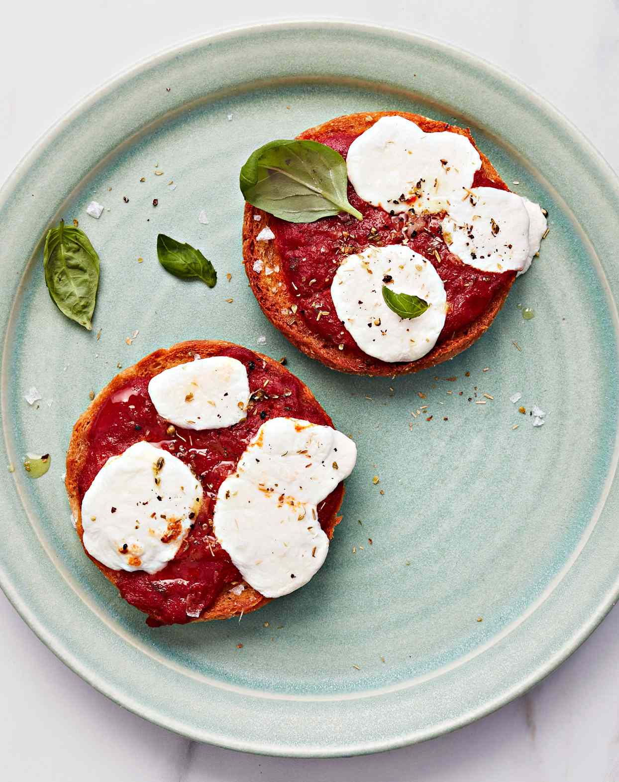 english muffin pizza snacks topped with fresh basil