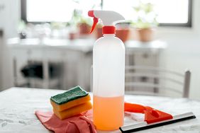 sponges, gloves and cleaning spray bottle on a table in a home