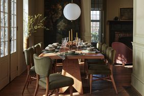 A dining room with green upholstered chairs 