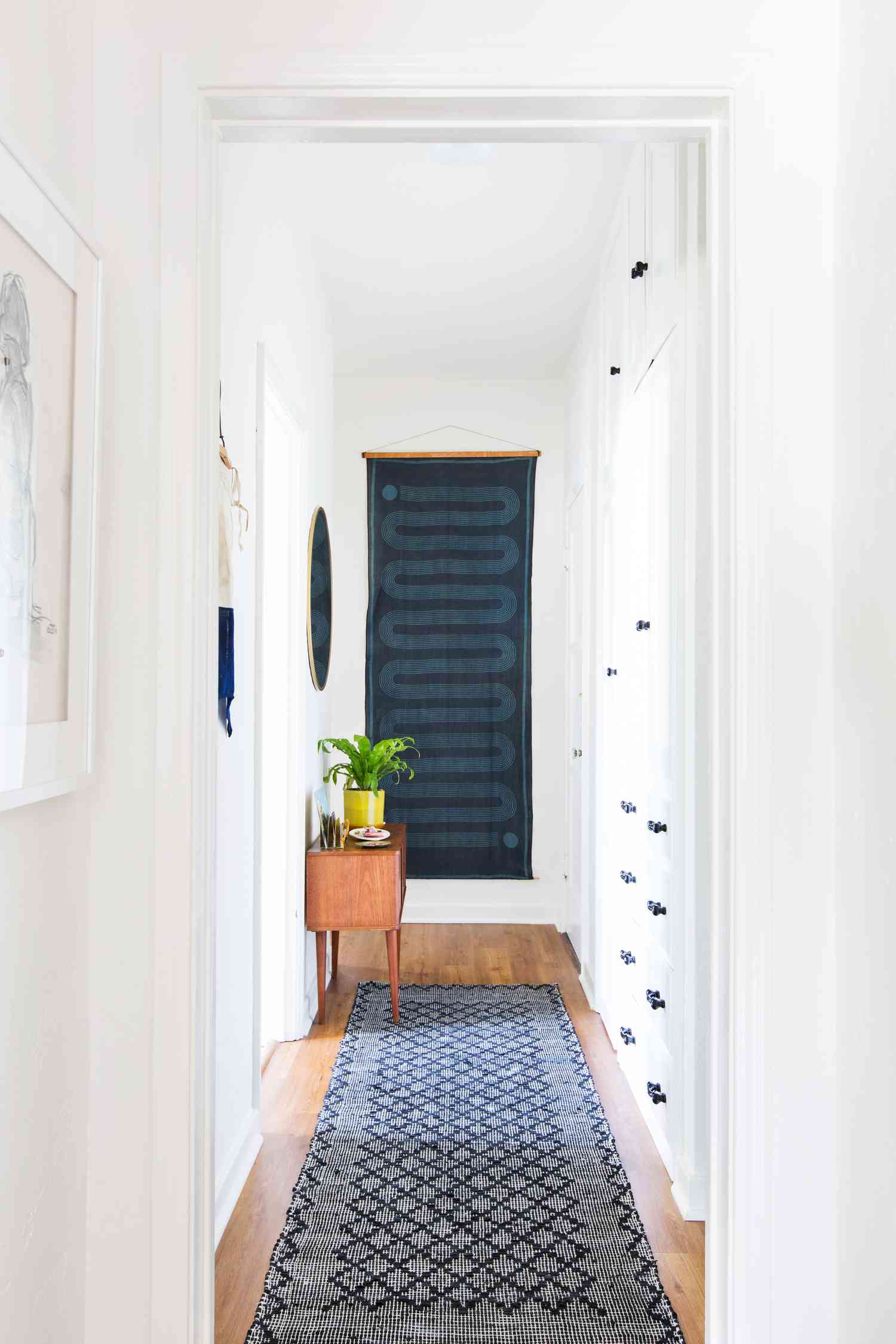White hallways with blue runner and tapestry