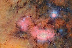 A view of the Trifid Nebula and surrounding region in space, showing detailed interstellar gas and light emissions
