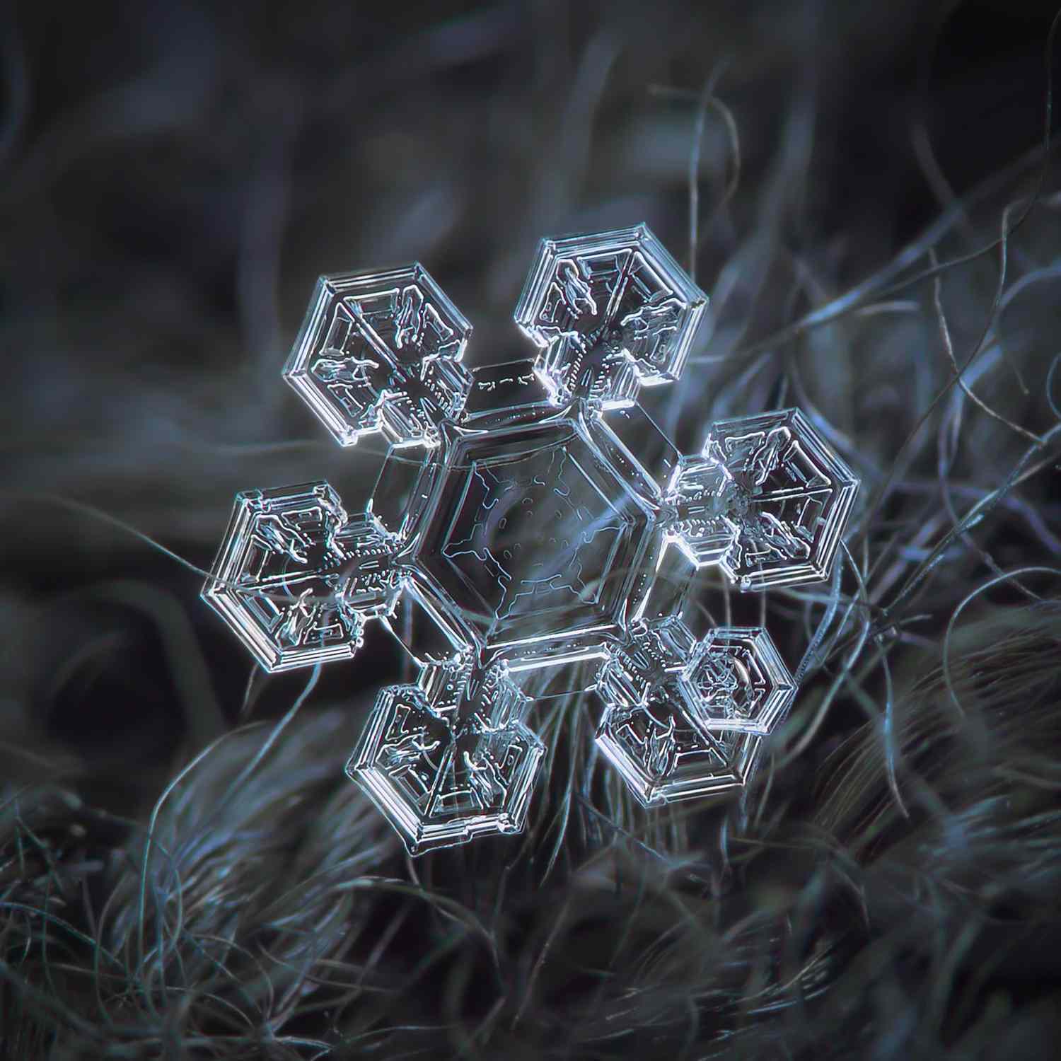 A detailed closeup of a snowflake resting on a textured surface showcasing its intricate structure and patterns