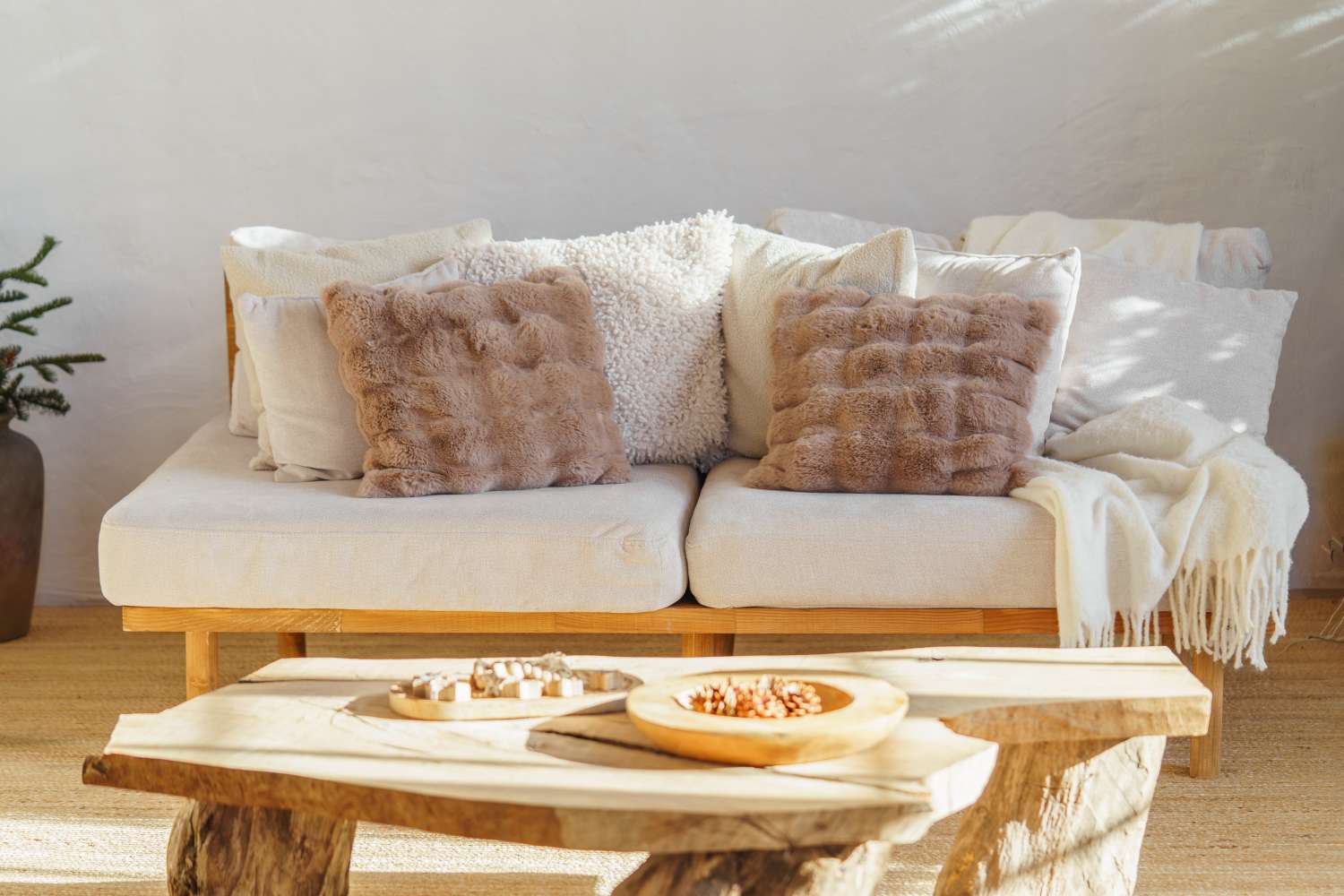 A cozy living area with a sofa featuring textured throw pillows and a rustic wooden coffee table