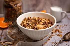 bowl of granola on a cutting board with spoon