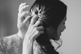 mother putting decorative clip in bride's hair