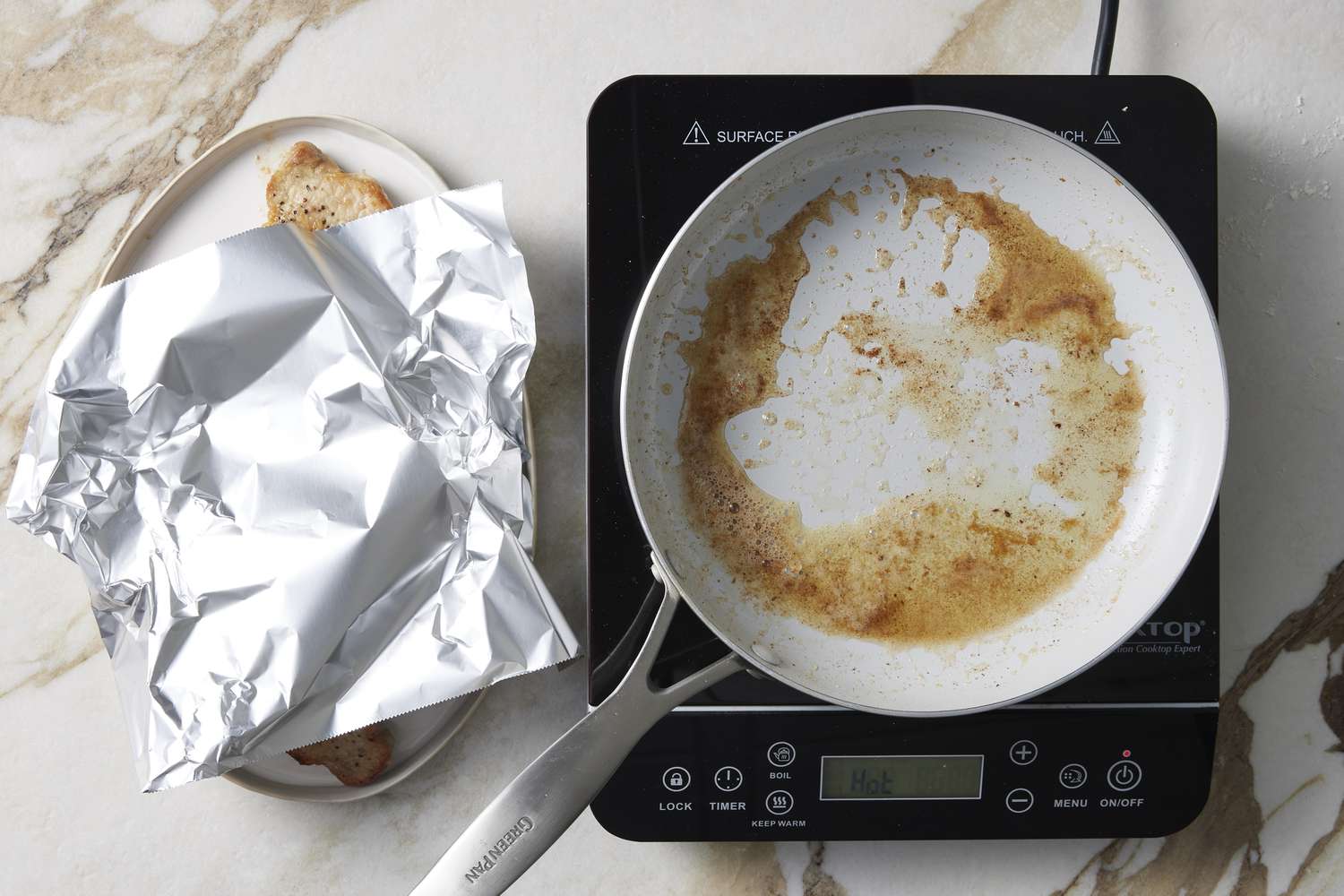 frying pan next to platter with pork covered in foil