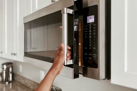 woman opening microwave
