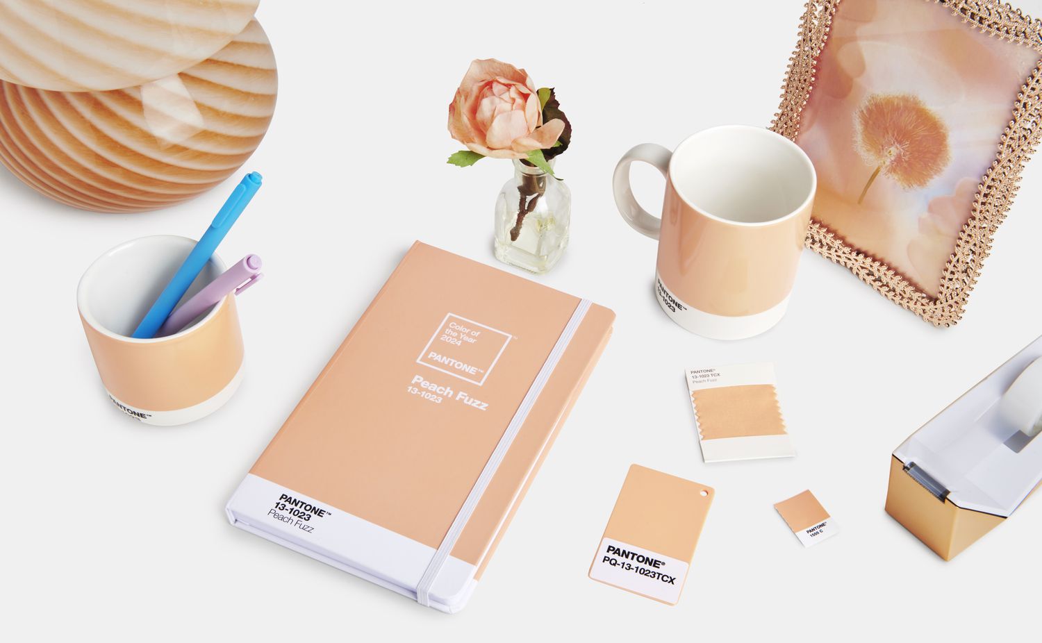 Lamp, notebook, coffee mug, and various supplies all painted in Pantone's 2024 color of the year. 