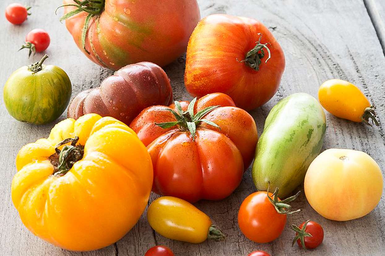 Various heirloom tomatoes on a wood table
