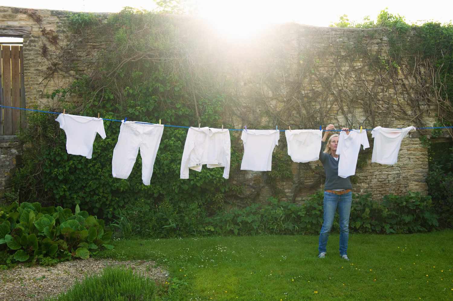 woman hanging up laundry on washing line outside