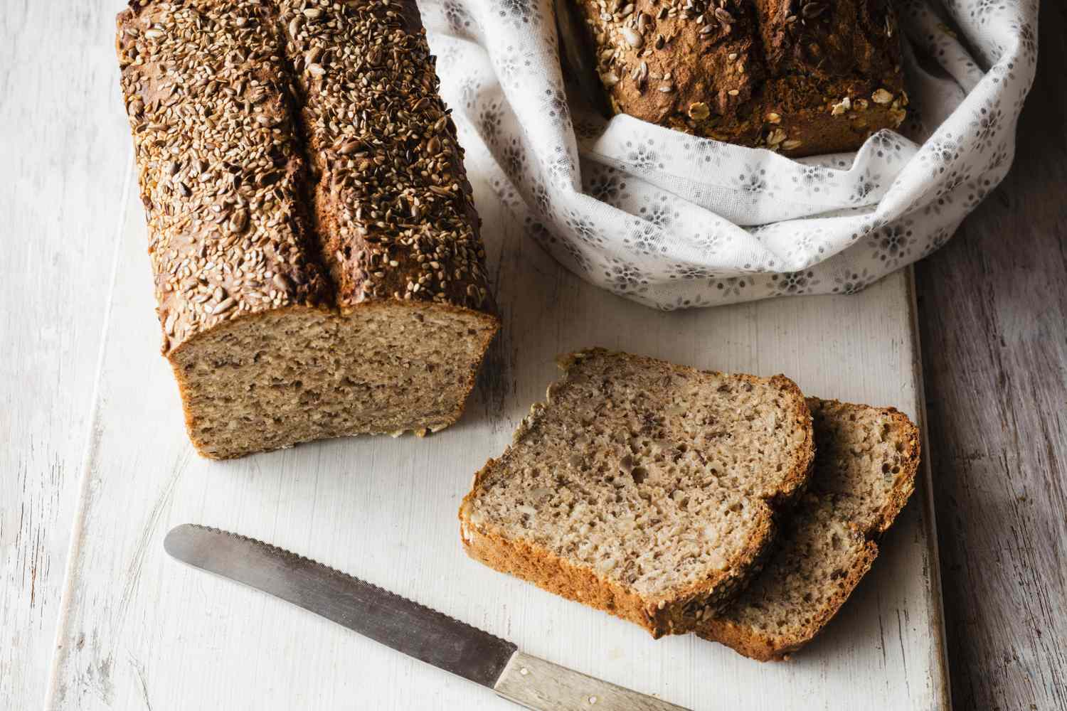 seeded bread, loaf and slices plus knife