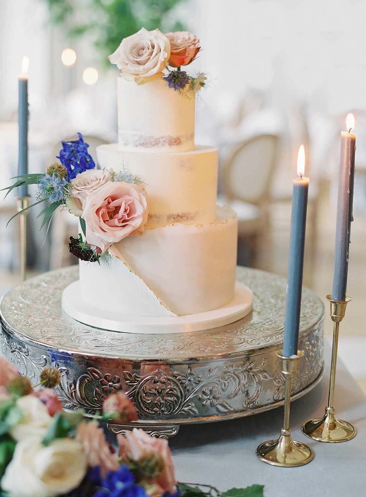 three tiered white frosted wedding cake with floral details