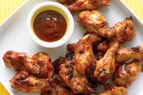 A plate of chicken drummettes with dipping sauce