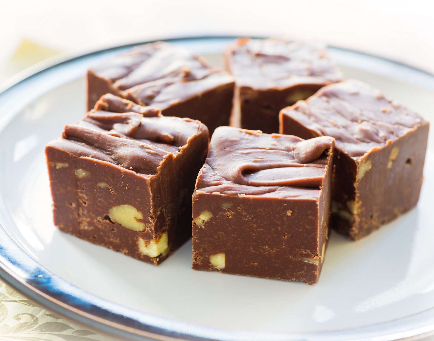 Homemade fudge with nuts and arranged on a small plate.