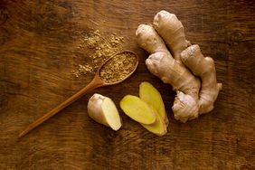 ginger root and wooden spoon with powdered ginger