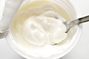 Top view of yogurt in a cup with a spoon inserted