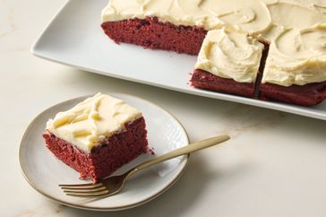 Red velvet sheet cake with a piece served on a plate with a fork