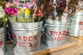 Metal buckets labeled Trader Joes holding bouquets of flowers