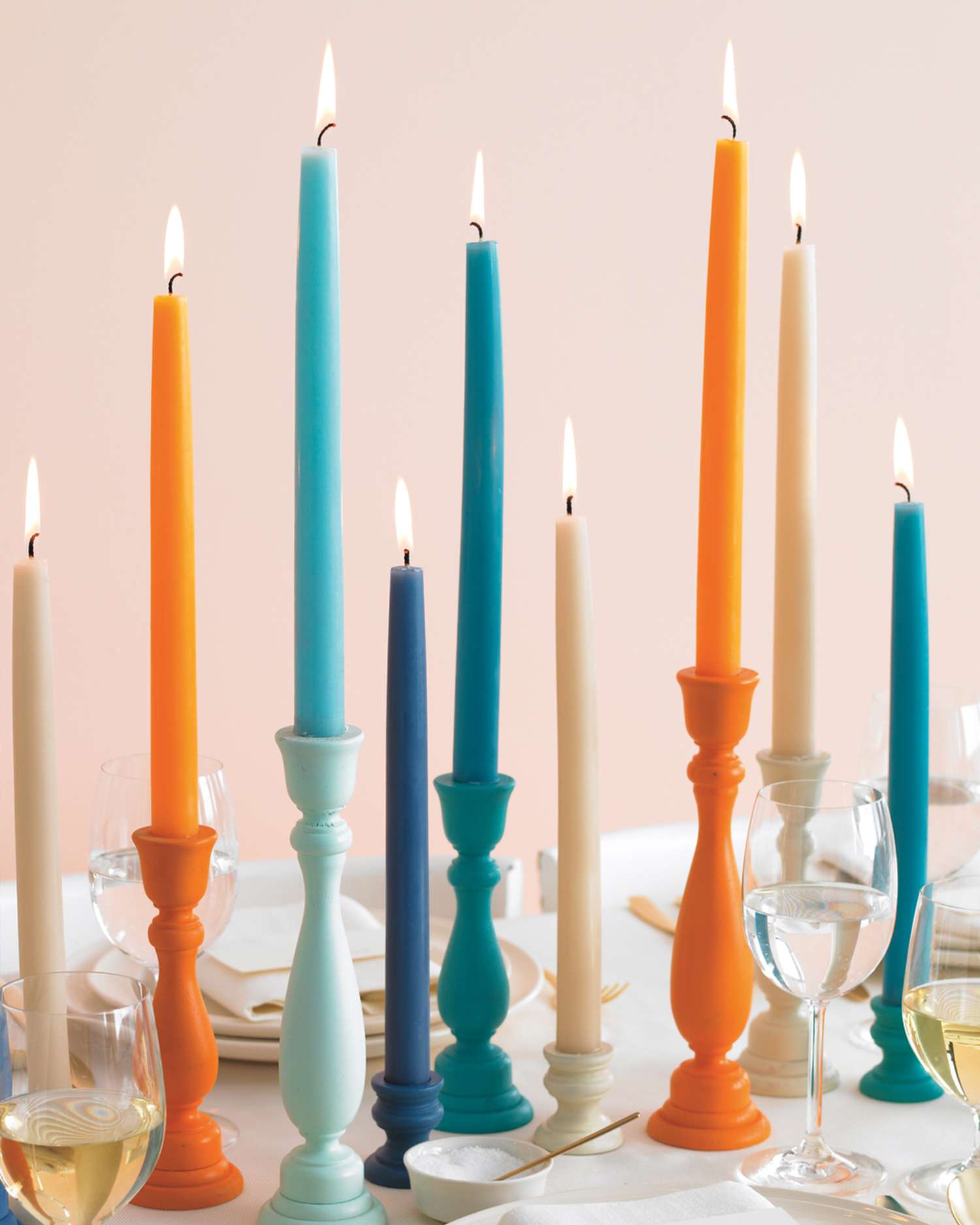 colorful candle holders and tapered candles on a dining table