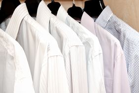A row of neatly hung collared shirts on hangers