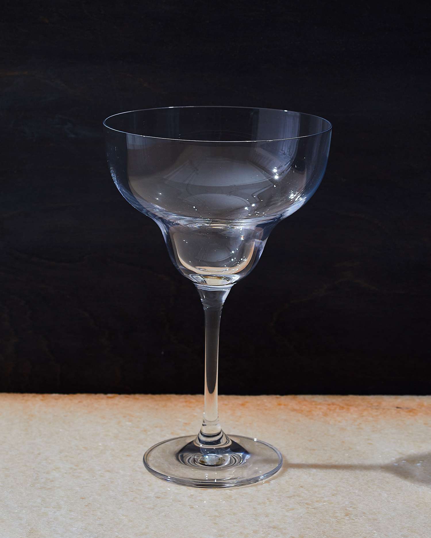 margarita glass on a beige surface with dark background