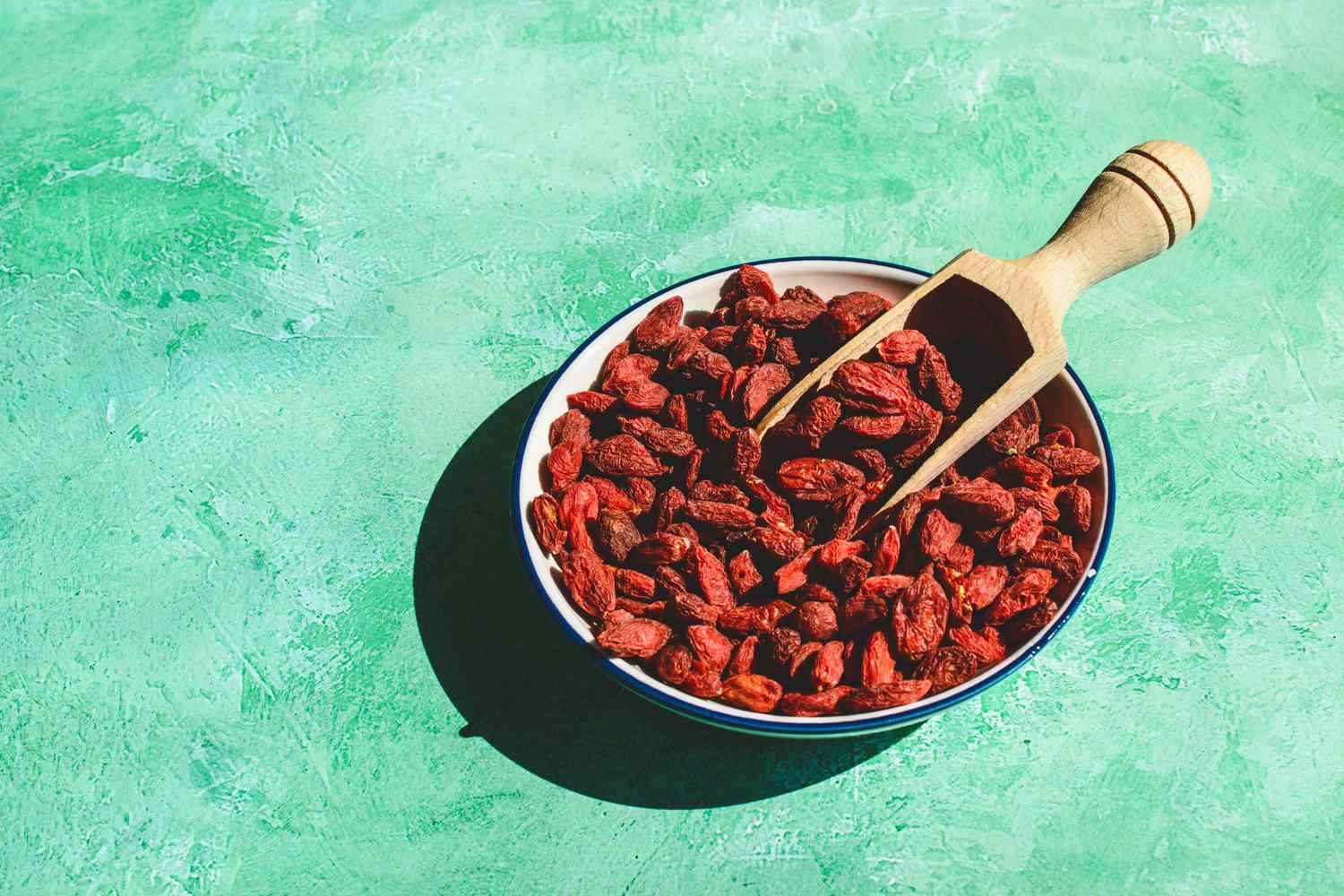 goji berries in bowl with wooden spoon