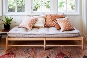 Daybed with throw pillows underneath a window