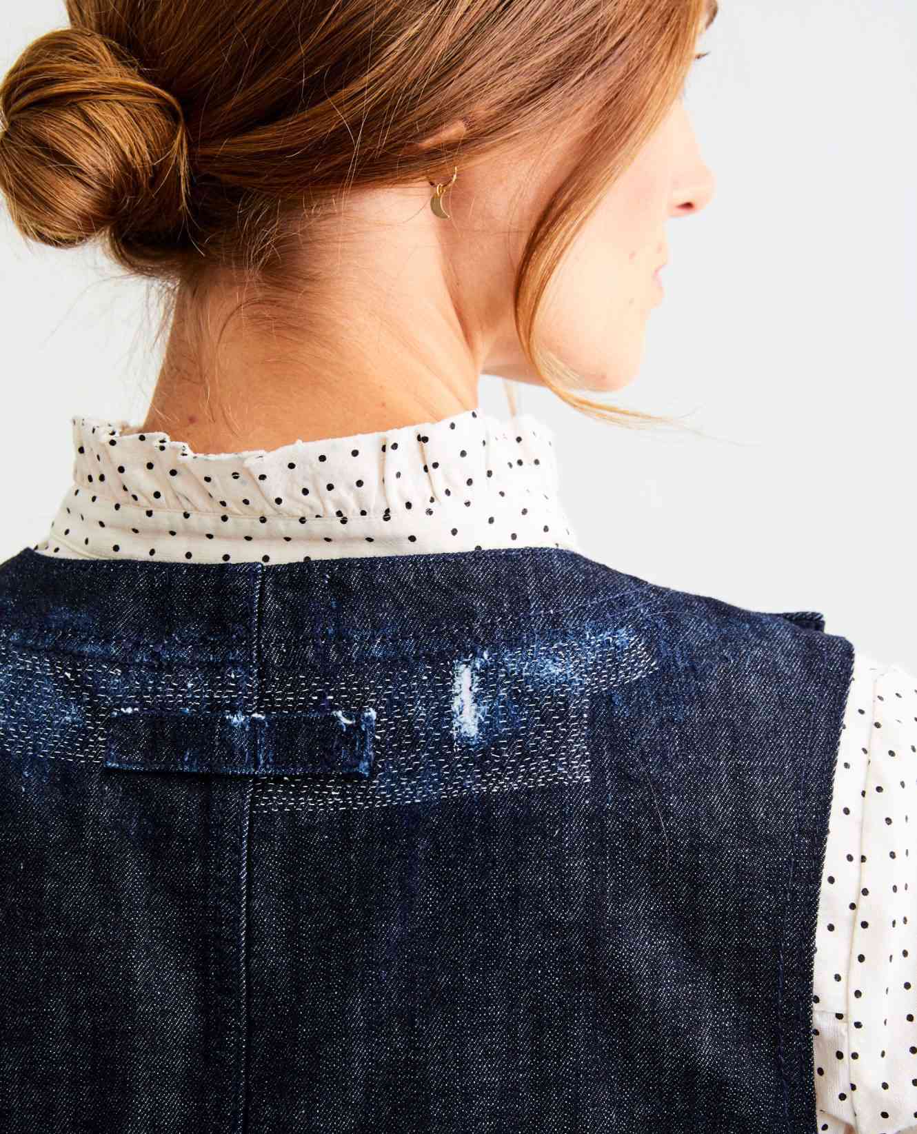 a woman wearing a mended denim dress