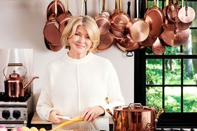 decorvow in a kitchen with copper pots and pans hanging behind her smiling while preparing food