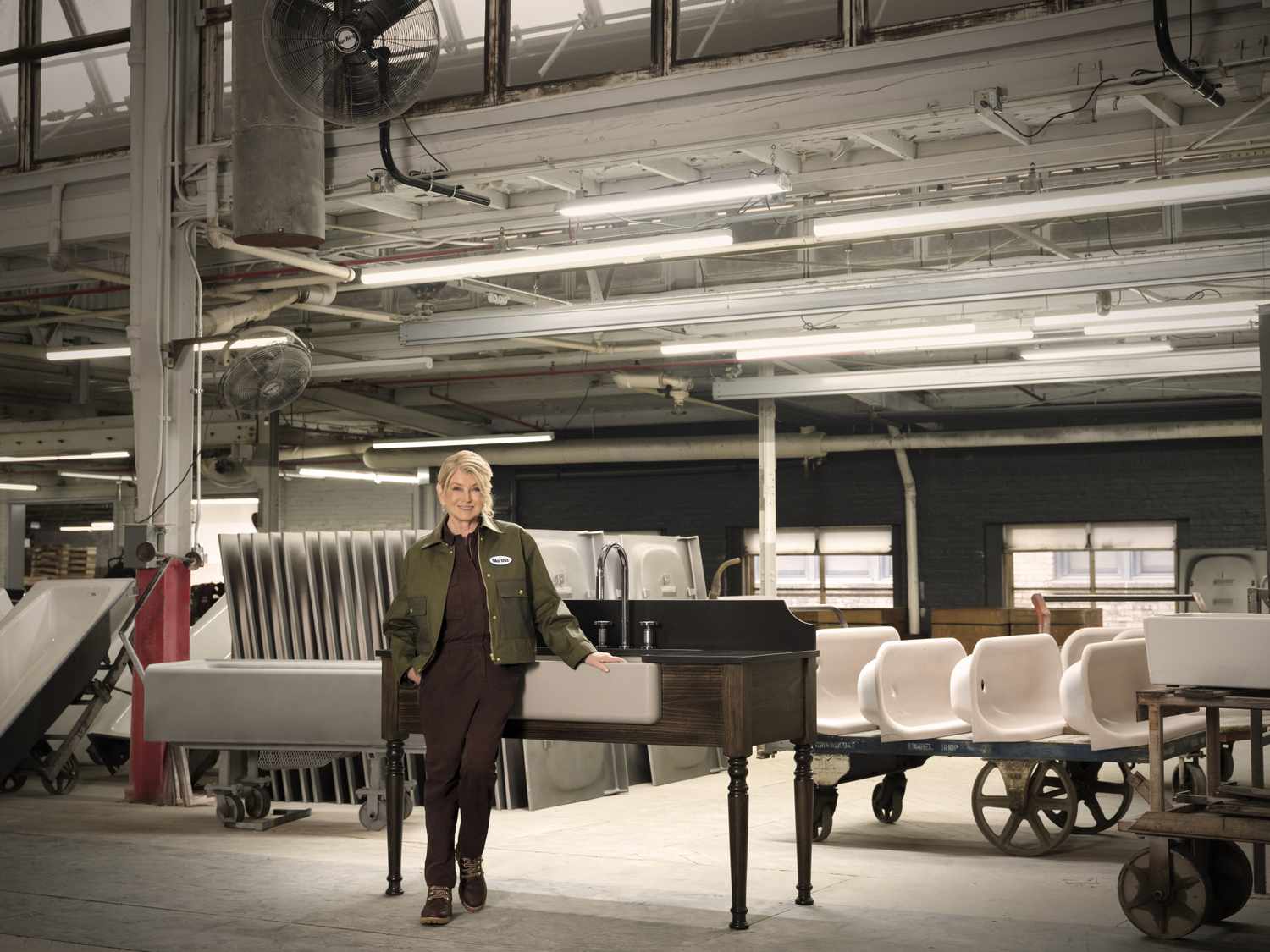A person standing next to a piano inside a warehouselike setting industrial elements and furniture visible in the background