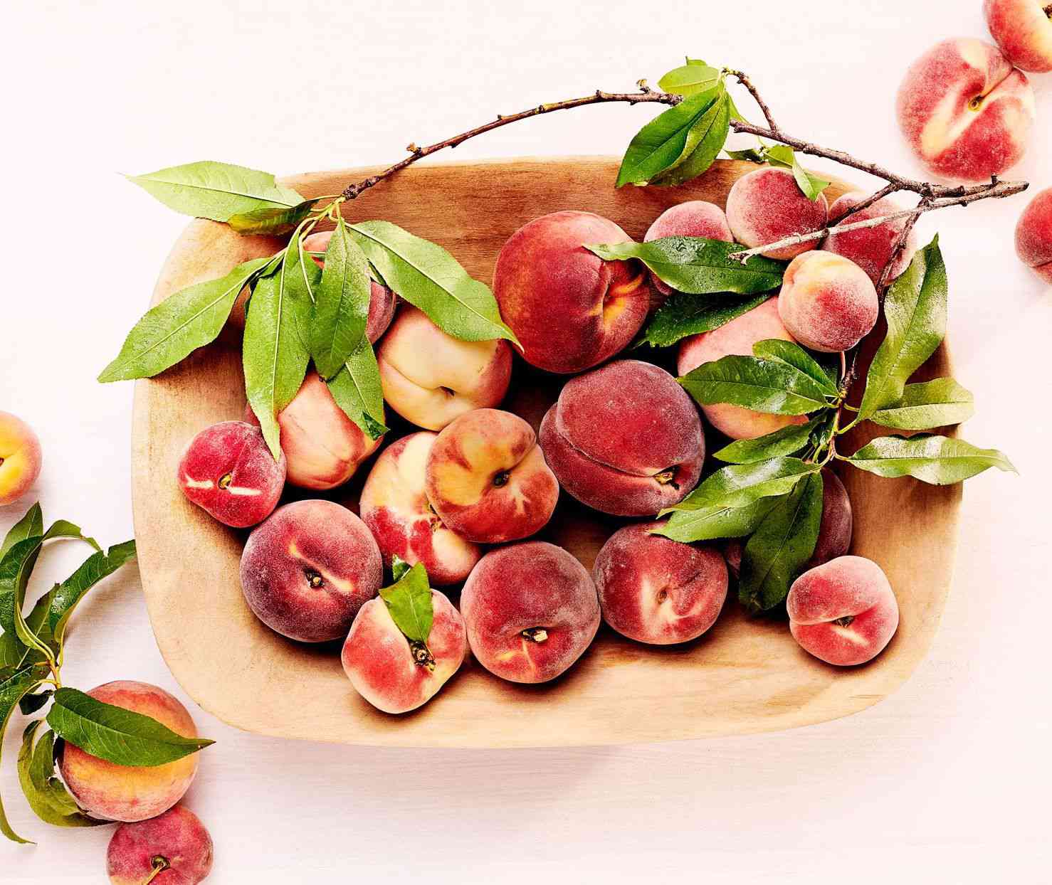 Wooden bowl with peaches
