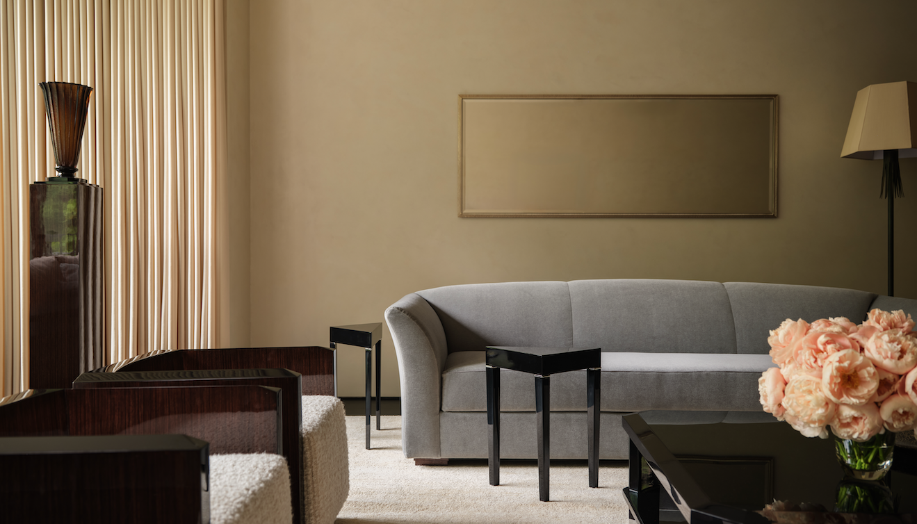 A modern living room setup with a sofa armchairs and a vase of flowers