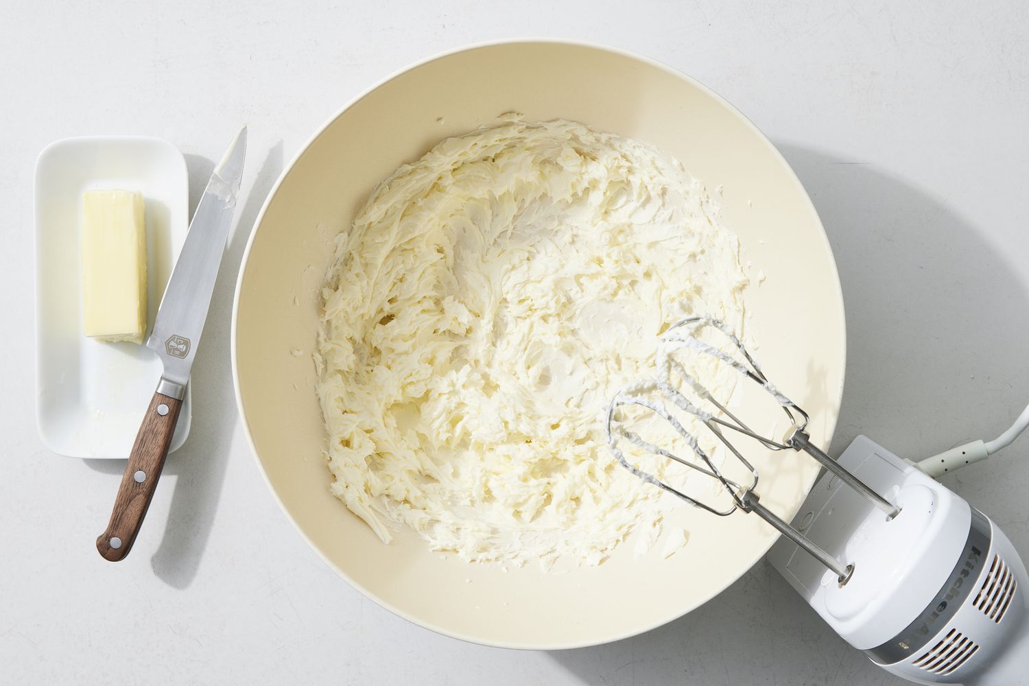 Overhead view of frosting with mixer and butter