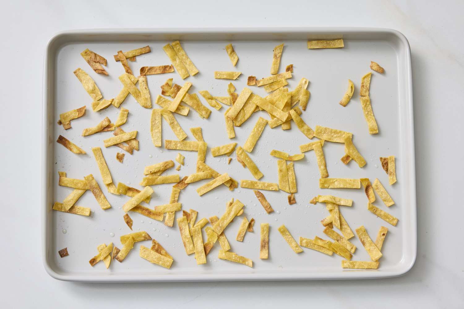 Baked tortilla strips on a baking sheet