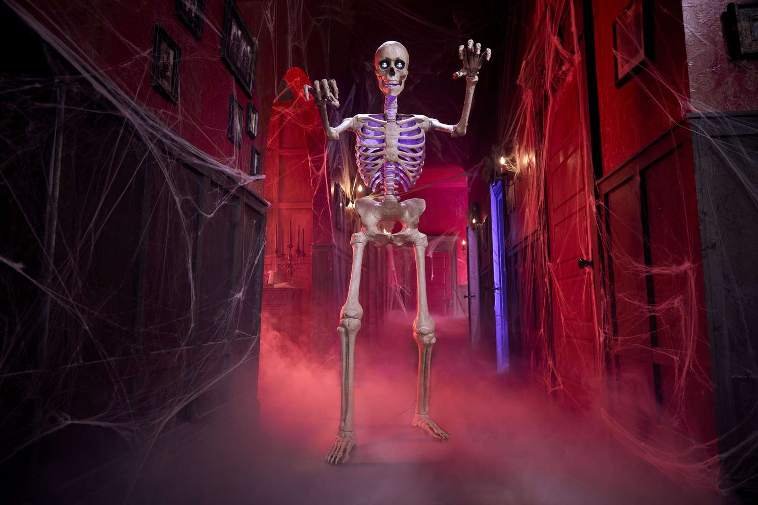 An animated skeleton prop standing tall in a spooky hall with fog and Halloween decor