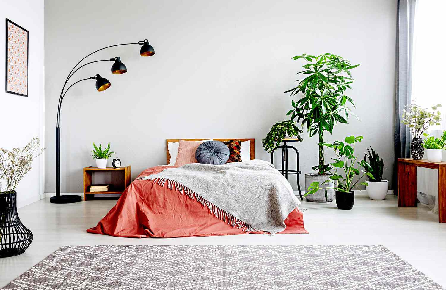 Bedroom with salmon and gray blankets, plants