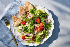 Plate of Greek salad with pita on a blue napkin