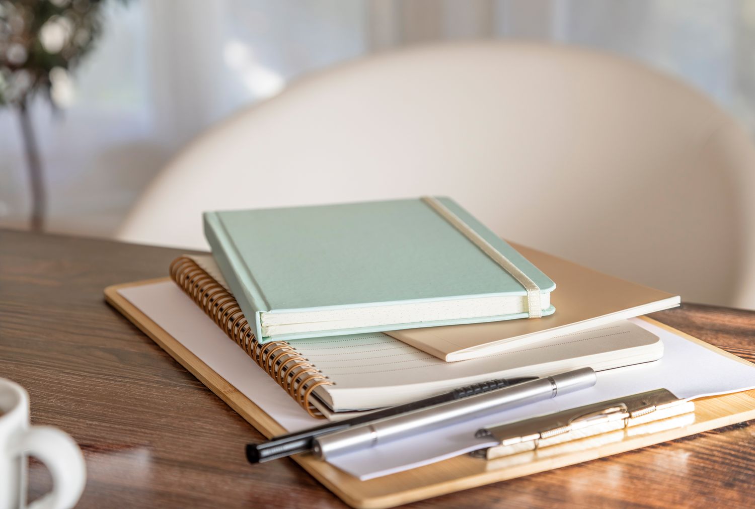 Journals notebooks and a pen arranged on a desk
