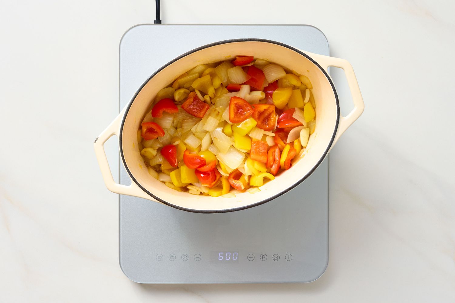 A pot of chopped vegetables on an induction cooktop