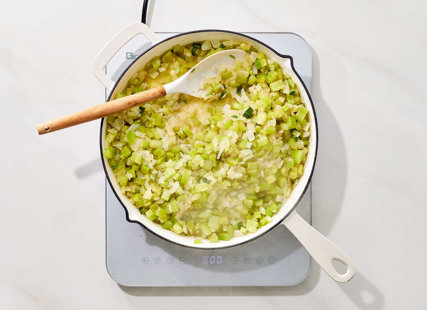 overhead view of celery and onions cooking in a pot