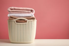 bsket of folded laundry against pink background